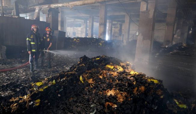 Firefighters work to douse a fire inside a food and beverage factory in Rupganj, outside Dhaka, Bangladesh, Friday, July 9, 2021. At least 52 people died in a huge blaze that engulfed a food and beverage factory outside Bangladesh&#x27;s capital, fire officials said Friday, in the latest industrial disaster to hit the South Asian nation. (AP Photo/Mahmud Hossain Opu)
