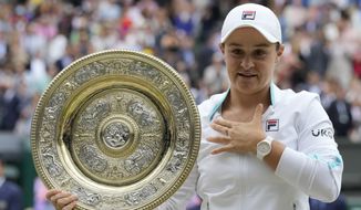 Australia&#39;s Ashleigh Barty poses with the trophy for the media after winning the women&#39;s singles final, defeating the Czech Republic&#39;s Karolina Pliskova on day twelve of the Wimbledon Tennis Championships in London, Saturday, July 10, 2021. (AP Photo/Kirsty Wigglesworth)