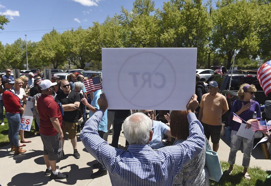 In this May 25, 2021, file photo, a man holds up a sign against Critical Race Theory during a protest outside a Washoe County School District board meeting in Reno, Nev. (Andy Barron/Reno Gazette-Journal via AP, File)  **FILE**