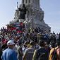 Anti-government protesters gather at the Maximo Gomez monument in Havana, Cuba, Sunday, July 11, 2021. Hundreds of demonstrators took to the streets in several cities in Cuba to protest against ongoing food shortages and high prices of foodstuffs. (AP Photo/Eliana Aponte)