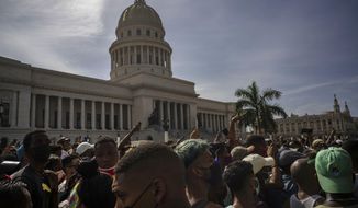 People protest in front of the Capitol in Havana, Cuba, Sunday, July 11, 2021. Hundreds of demonstrators went out to the streets in several cities in Cuba to protest against ongoing food shortages and high prices of foodstuffs, amid the new coronavirus crisis. (AP Photo/Ramon Espinosa)