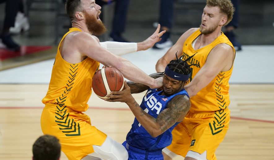 United States&#39; Bradley Beal drives into Australia&#39;s Aron Baynes, left, and Jock Landale, right, during an exhibition basketball game Monday, July 12, 2021, in Las Vegas. (AP Photo/John Locher)