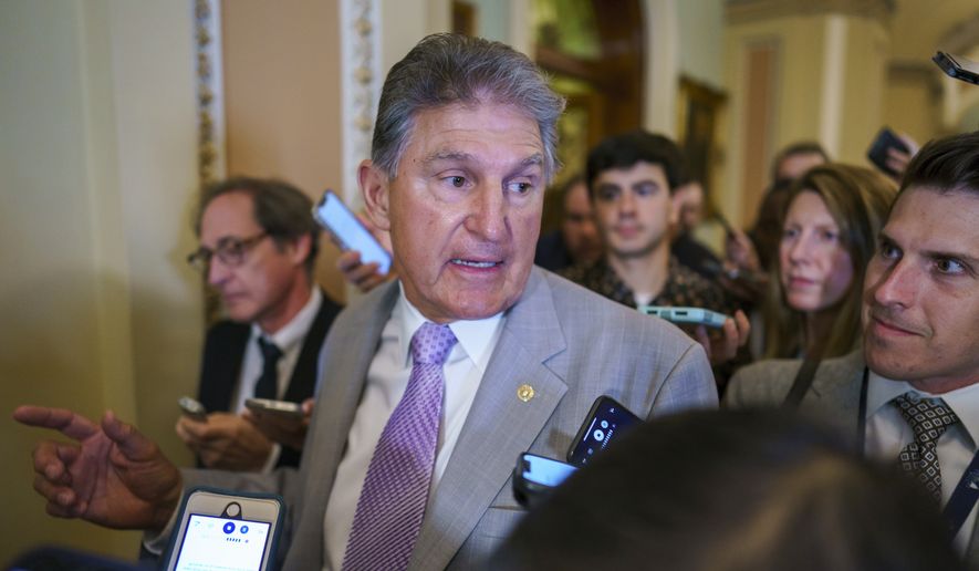 Sen. Joe Manchin, D-W.Va., a key negotiator in the infrastructure talks, is surrounded by reporters as walks through the Capitol in Washington, Tuesday, July 13, 2021. (AP Photo/J. Scott Applewhite)
