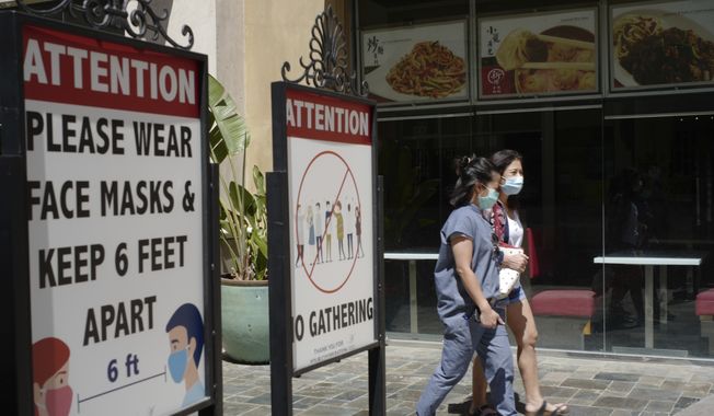Customers wear face masks in an outdoor mall with closed business amid the COVID-19 pandemic in Los Angeles. Coronavirus cases have jumped 500% in Los Angeles County over the past month and health officials warned Tuesday, July 13, 2021, that the especially contagious delta variant of the disease continues to spread rapidly among California&#x27;s unvaccinated population. (AP Photo/Damian Dovarganes,File)