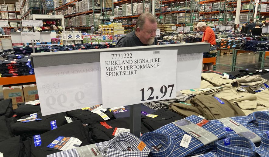 A sign displays the price for shirts as a shopper peruses the offerings at a Costco warehouse on Thursday, June 17, 2021, in Lone Tree, Colo. American consumers faced a third straight monthly surge in princes in June, the latest sign that a rapid reopening of the economy is fueling a pent-up demand for goods and services that in many cases remain in short supply.  (AP Photo/David Zalubowski)