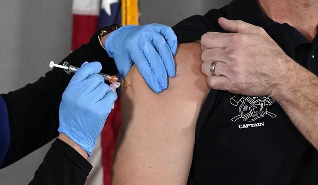 In this Wednesday, Dec. 16, 2020, file photo, the Pfizer vaccine for COVID-19 is administered at the Arizona Department of Health Services State Laboratory in Phoenix. (AP Photo/Ross D. Franklin, File)