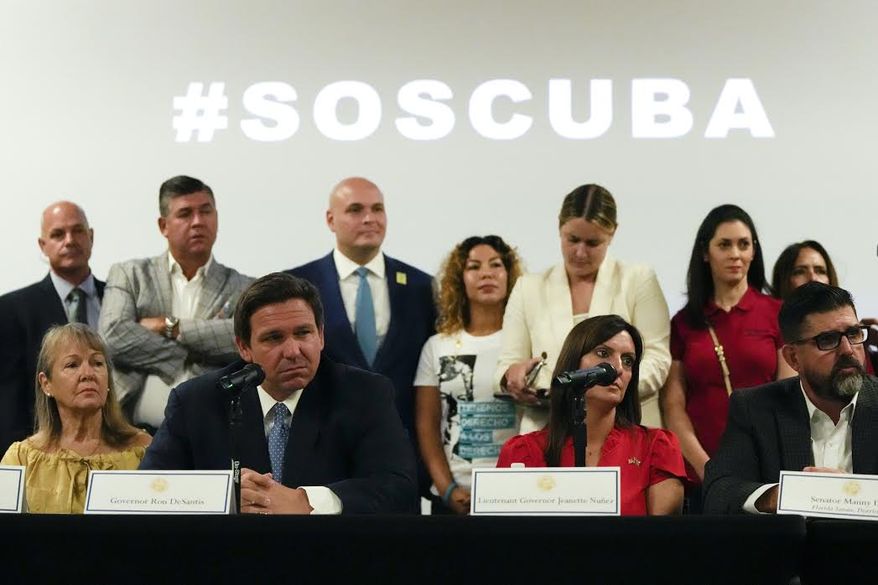 Florida Gov. Ron DeSantis, seated at left, discusses the situation in Cuba at the American Museum of the Cuban Diaspora in Miami. (AP Photo/Rebecca Blackwell)