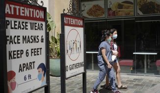 File - In this June 11, 2021 file photo customers wear face masks in an outdoor mall with closed business amid the COVID-19 pandemic in Los Angeles. Coronavirus cases have jumped 500% in Los Angeles County over the past month and health officials warned Tuesday, July 13, 2021, that the especially contagious delta variant of the disease continues to spread rapidly among California&#x27;s unvaccinated population. (AP Photo/Damian Dovarganes,File)