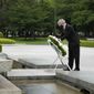 International Olympic Committee President Thomas Bach offers flowers to Hiroshima Memorial Cenotaph during his visit Friday, July 16, 2021, in Hiroshima, western Japan. (AP Photo/Eugene Hoshiko, Pool)