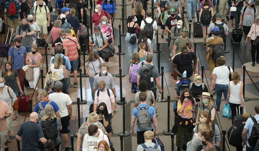 FILE - In this June 16, 2021 file photo, travelers queue up in long lines to pass through the south security checkpoint in Denver International Airport in Denver. A seemingly offhand remark by President Joe Biden is raising hopes in the airline industry that the U.S. might soon open up to European visitors. If it happens soon, it might salvage some last-minute, late-summer vacation-travel business for the airlines. (AP Photo/David Zalubowski, File)