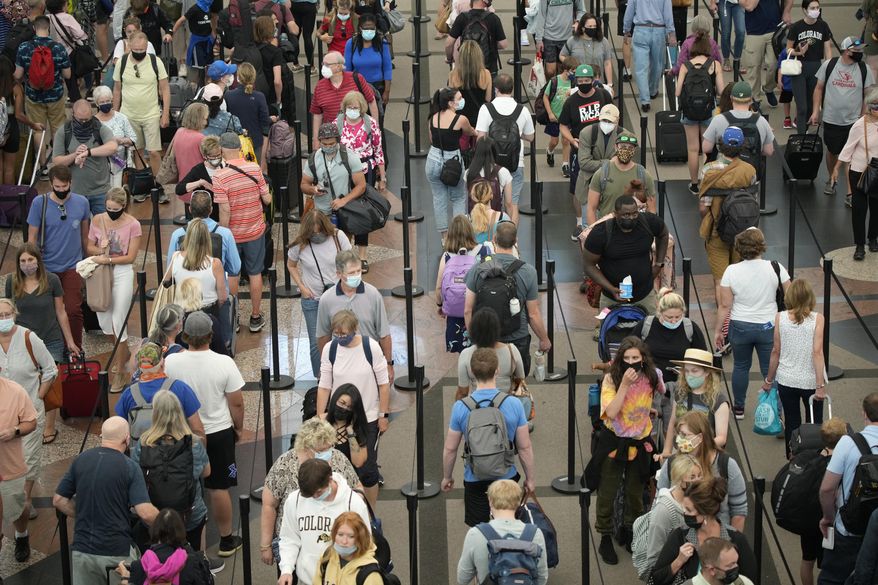 FILE - In this June 16, 2021 file photo, travelers queue up in long lines to pass through the south security checkpoint in Denver International Airport in Denver. A seemingly offhand remark by President Joe Biden is raising hopes in the airline industry that the U.S. might soon open up to European visitors. If it happens soon, it might salvage some last-minute, late-summer vacation-travel business for the airlines. (AP Photo/David Zalubowski, File)