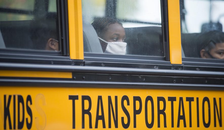 In this Oct. 12, 2020, file photo, students arrive by bus at Foundation Preparatory School for their return to school during the coronavirus in New Orleans. It was the first day of in-person learning for fifth-12th grade public school students in Orleans Parish. Despite climbing numbers of COVID-19 cases around Louisiana, state education leaders are leaving decisions on mask mandates, physical distancing and other measures aimed at lessening coronavirus spread to local public school districts for the upcoming year. (Chris Granger/The Times-Picayune/The New Orleans Advocate via AP, File)