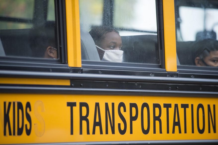 In this Oct. 12, 2020, file photo, students arrive by bus at Foundation Preparatory School for their return to school during the coronavirus in New Orleans. It was the first day of in-person learning for fifth-12th grade public school students in Orleans Parish. Despite climbing numbers of COVID-19 cases around Louisiana, state education leaders are leaving decisions on mask mandates, physical distancing and other measures aimed at lessening coronavirus spread to local public school districts for the upcoming year. (Chris Granger/The Times-Picayune/The New Orleans Advocate via AP, File)