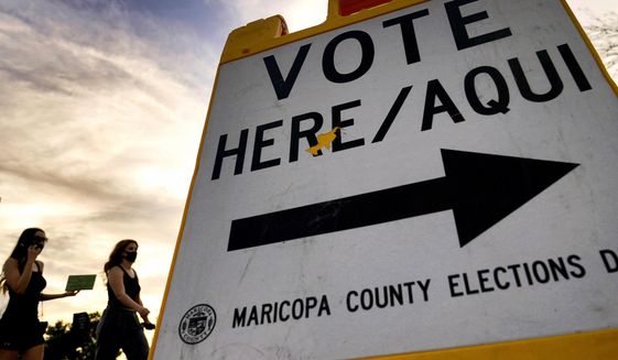In this Nov. 3, 2020, file photo voters deliver their ballot to a polling station in Tempe, Ariz. (AP Photo/Matt York, File)