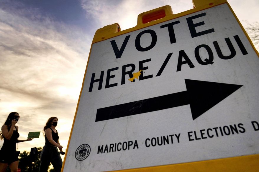 In this Nov. 3, 2020, file photo voters deliver their ballot to a polling station in Tempe, Ariz. (AP Photo/Matt York, File)