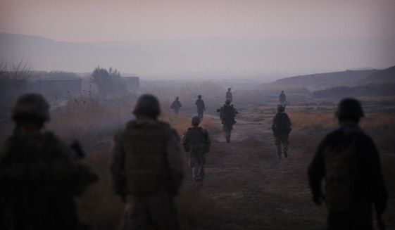 In this Dec. 23, 2009, file photo United States Marines from the 2nd Battalion 2nd Marines &quot;Warlords&quot; and Afghan National Army soldiers walk in formation during an operation in the Garmsir district of the volatile Helmand province, southern Afghanistan. (AP Photo/Kevin Frayer, File)