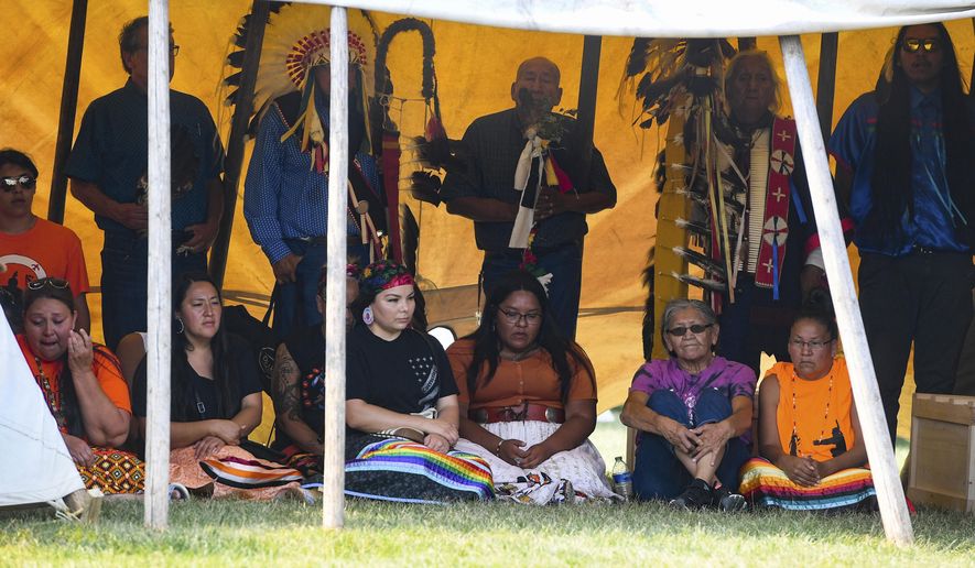 Family members of the nine children whose remains returned to South Dakota gather with the remains before private prayer and ceremony Friday, July 16, 2021 on the Yankton Sioux Reservation in South Dakota. The disinterred remains of nine Native American children who died more than a century ago while attending a government-run school in Pennsylvania are headed home to Rosebud Sioux tribal lands in South Dakota. (Erin Bormett/The Argus Leader via AP)
