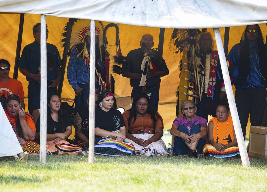 Family members of the nine children whose remains returned to South Dakota gather with the remains before private prayer and ceremony Friday, July 16, 2021 on the Yankton Sioux Reservation in South Dakota. The disinterred remains of nine Native American children who died more than a century ago while attending a government-run school in Pennsylvania are headed home to Rosebud Sioux tribal lands in South Dakota. (Erin Bormett/The Argus Leader via AP)