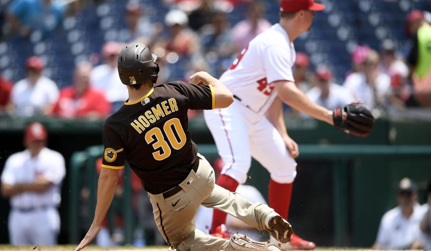 San Diego Padres' Eric Hosmer (30) starts his slide toward home to score on a single by Tommy Pham as Washington Nationals relief pitcher Sam Clay, right, looks for the ball during the seventh inning of the continuation of a suspended baseball game, Sunday, July 18, 2021, in Washington. (AP Photo/Nick Wass)