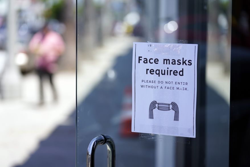 A sign advises shoppers to wear masks outside of a story Monday, July 19, 2021, in the Fairfax district of Los Angeles. Los Angeles County has reinstated an indoor mask mandate due to rising COVID-19 cases. (AP Photo/Marcio Jose Sanchez)