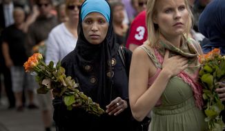 In this Sunday, July 24, 2011, file photo, women carry flowers as they arrive for a memorial service at Oslo Cathedral in the aftermath of the bombing and shooting attacks on Norway&#39;s government headquarters and a youth retreat, in Oslo. On the 10-year anniversary of Norway’s worst peacetime slaughter, survivors of Anders Breivik’s 22 July assault worry that the seam of racism that nurtured the anti-Islamic mass-murderer is re-emerging. Most of Breivik’s 77 victims were teen members of the Labor Party Youth wing — idealists enjoying their annual camping trip on the tranquil, wooded island of Utoya. Today many survivors are battling to keep their vision for their country alive. (AP Photo/Emilio Morenatti, File)