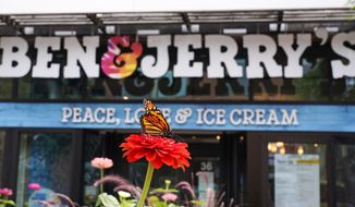 A Monarch butterfly lands on a flower outside the Ben &amp; Jerry&#x27;s Ice Cream shop, Tuesday, July 20, 2021, in Burlington, Vt. Ben &amp; Jerry&#x27;s said Monday it was going to stop selling its ice cream in the Israeli-occupied West Bank and contested east Jerusalem, saying the sales in the territories sought by the Palestinians are &quot;inconsistent with our values&quot;. (AP Photo/Charles Krupa)