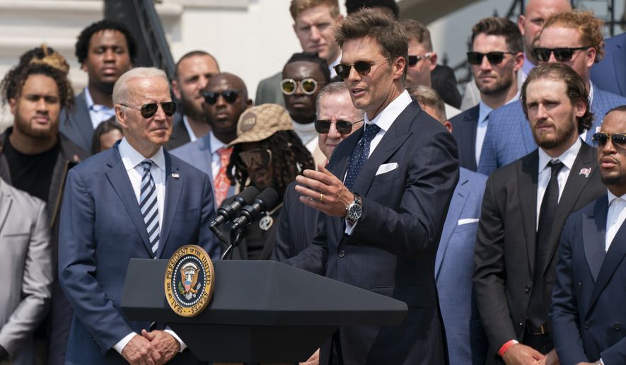 President Joe Biden listens to Tampa Bay Buccaneers quarterback Tom Brady speak during a ceremony on the South Lawn of the White House, in Washington, Tuesday, July 20, 2021, where the president honored the Super Bowl Champion Tampa Bay Buccaneers for their Super Bowl LV victory. (AP Photo/Manuel Balce Ceneta)