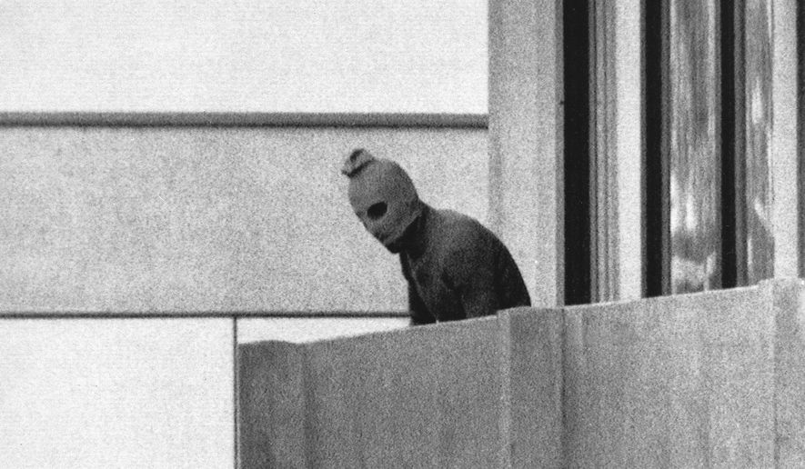 In this Sept. 5, 1972, file photo, a member of the Arab Commando group which seized members of the Israeli Olympic Team at their quarters at the Munich Olympic Village, appears with a hood over his face on the balcony of the village building where the commandos held members of the Israeli team hostage. (AP Photo/Kurt Strumpf, File)  **FILE**