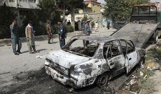 Security personnel inspect a damaged vehicle where rockets were fired from in Kabul, Afghanistan, Tuesday, July 20, 2021. At least three rockets hit near the presidential palace on Tuesday shortly before Afghan President Ashraf Ghani was to give an address to mark the Muslim holiday of Eid-al-Adha. (AP Photo/Rahmat Gul)