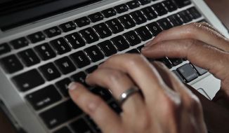 In this June 19, 2017, file photo, a person types on a laptop keyboard in North Andover, Mass. (AP Photo/Elise Amendola, File)