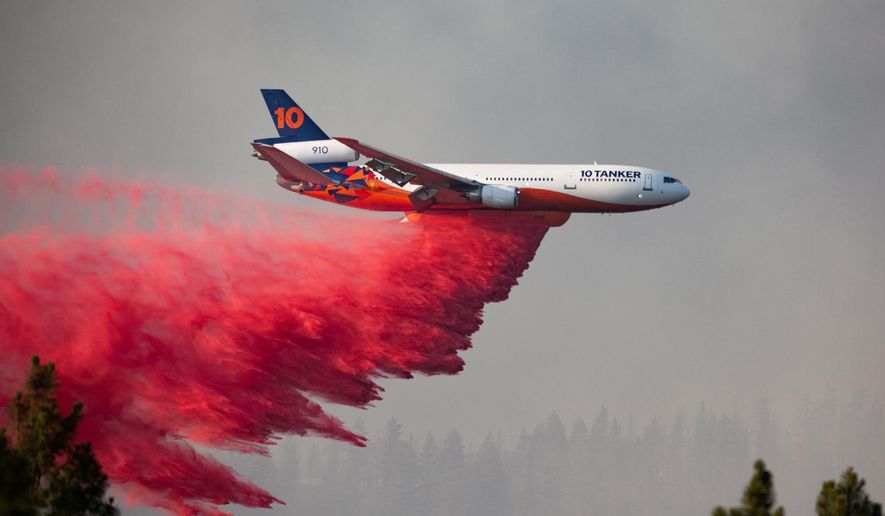 In this photo provided by the Bootleg Fire Incident Command, a DC-10 tanker drops retardant over the Bootleg Fire in southern Oregon, Thursday, July 15, 2021. Meteorologists predicted critically dangerous fire weather through at least Monday with lightning possible in both California and southern Oregon. (Bootleg Fire Incident Command via AP)