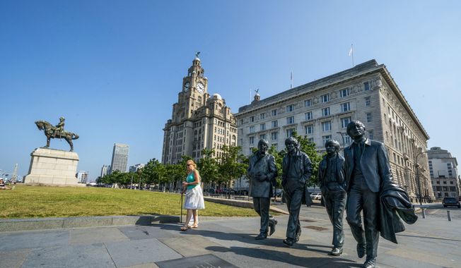 The Beatles statues and Royal Liver Building, center, on the waterfront area of Liverpool, which has been removed from the World Heritage List on Wednesday July 21, 2021.  The UN World Heritage Committee found developments including the new Everton soccer stadium threatened the value of the city&#x27;s waterfront. (Peter Byrne/PA via AP)