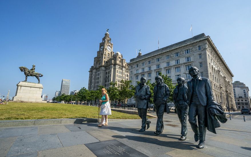 The Beatles statues and Royal Liver Building, center, on the waterfront area of Liverpool, which has been removed from the World Heritage List on Wednesday July 21, 2021.  The UN World Heritage Committee found developments including the new Everton soccer stadium threatened the value of the city's waterfront. (Peter Byrne/PA via AP)