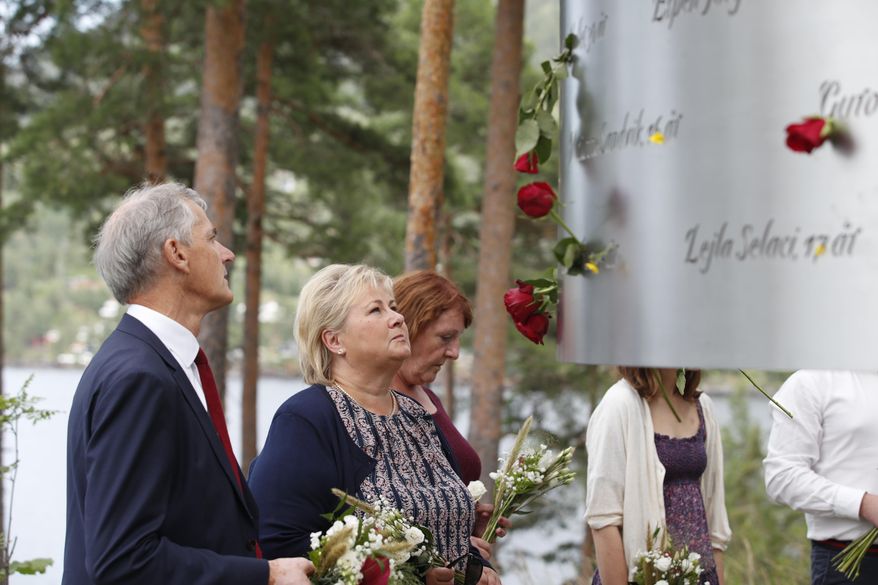 In this July 22, 2019, file photo, Norway&#x27;s Prime Minister Erna Solberg, center, and leader of the Labour party Jonas Gahr Stoere, left, attend a memorial ceremony to mark the 8th anniversary of the shootings on Utoya Island, where 69 people were killed by Anders Breivik. At 3.25 p.m. on July 22, 2021, a ray of sun should have illuminated the first of 77 bronze columns on a lick of land opposite Utoya island outside Oslo. Over the next 3 hours and 8 minutes, it would have brushed each column in turn, commemorating every person killed by right-wing terrorist Anders Breivik. But on the 10-year anniversary of the terror, the memorial remains a construction site. (Terje Bendiksby/NTB Scanpix via AP, File)
