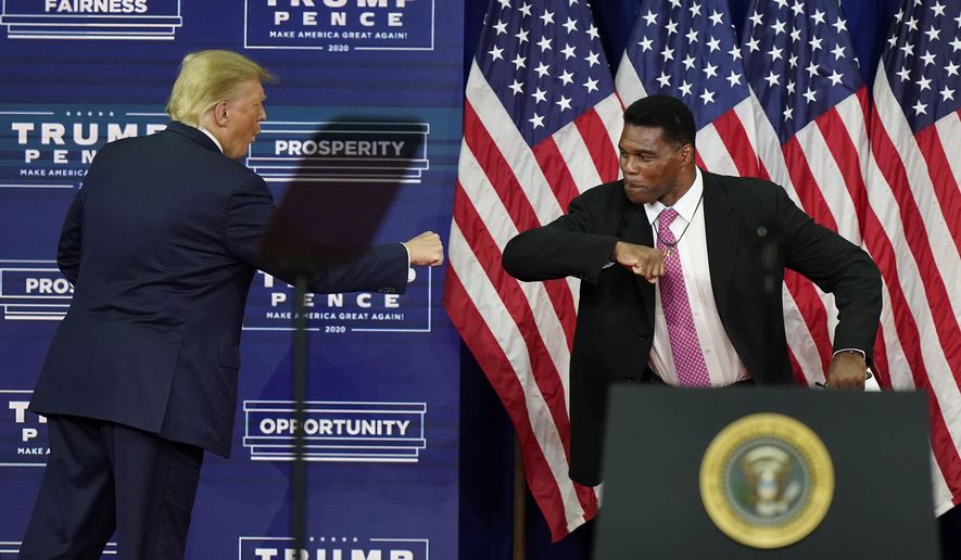 In this Sept. 25, 2020, file photo, President Donald Trump elbow bumps with Herschel Walker during a campaign rally in Atlanta. (AP Photo/John Bazemore, File)  **FILE**
