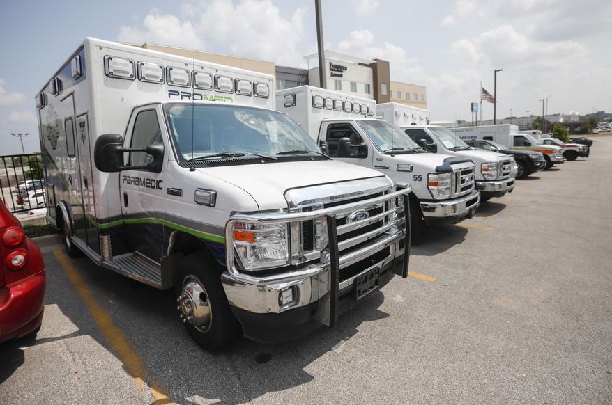Ambulance crews unload equipment at the DoubleTree Hotel on Friday, July 23, 2021, in Springfield, Mo. The crews are part of a medical team that was sent to Springfield to help transport COVID-19 patients in the area. (Andrew Jansen/The Springfield News-Leader via AP)