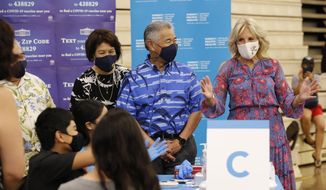 Hawaii Gov. David Ige, center, his wife Dawn Amano-Ige, left, and first lady Jill Biden, right, tour a COVID-19 vaccination clinic at a high school in Waipahu, Hawaii, Sunday, July 25, 2021. (AP Photo/Caleb Jones)