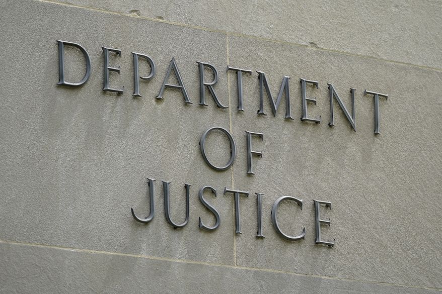 This May 4, 2021, file photo shows a sign outside the Robert F. Kennedy Department of Justice building in Washington. (AP Photo/Patrick Semansky)  ** FILE **