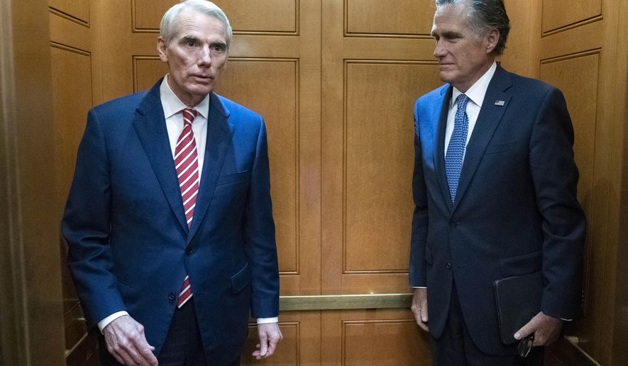 Sen. Rob Portman, R-Ohio, left, accompanied by Sen. Mitt Romney, R-Utah, leave in the elevator after a closed door talks about infrastructure on Capitol Hill in Washington Thursday, July 15, 2021. (AP Photo/Jose Luis Magana)  **FILE**