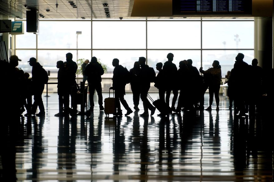 In this Wednesday, March 17, 2021 file photo, travelers walk through the Salt Lake City International Airport in Salt Lake City. A new report finds that 40% of U.S. business travelers who took at least three trips a year before the pandemic expect “never again” to travel for work due to rising prices. (AP Photo/Rick Bowmer, file) **FILE**