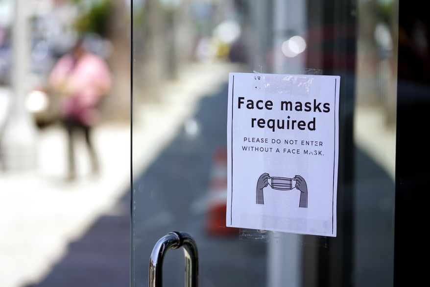 A sign advises shoppers to wear masks outside of a store Monday, July 19, 2021, in the Fairfax district of Los Angeles. Infections are climbing across the U.S. and mask mandates and other COVID-19 prevention measures are making a comeback in some places as health officials issue increasingly dire warnings about the highly contagious delta variant. But in a possible sign that the warnings are getting through to more Americans, vaccination rates are creeping up again, offering hope that the nation could yet break free of the coronavirus if people who have been reluctant to receive the shot are finally inoculated. (AP Photo/Marcio Jose Sanchez, File)