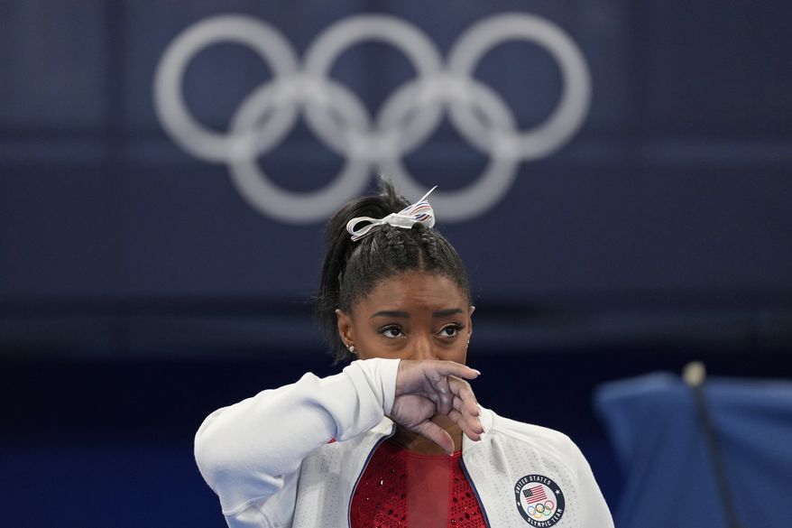 Simone Biles, of the United States, watches gymnasts perform at the 2020 Summer Olympics, Tuesday, July 27, 2021, in Tokyo. Biles says she wasn&#x27;t in right &#x27;headspace&#x27; to compete and withdrew from gymnastics team final to protect herself. (AP Photo/Ashley Landis)
