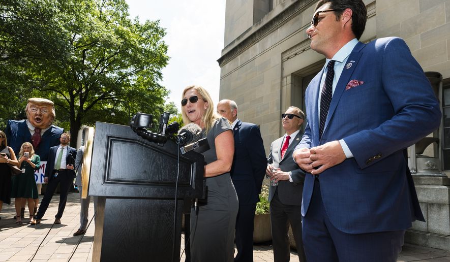 Rep. Marjorie Taylor Greene, R-Ga., left, together with Rep. Matt Gaetz, R-Fla.,right, and Rep. Louie Gohmert, R-Texas, back center, speaks in front of the Department of Justice building in Washington, during a rally, Tuesday, July 27, 2021, demanding the release of the Jan 6 &quot;prisoners.&quot; (AP Photo/Manuel Balce Ceneta)