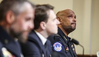 U.S. Capitol Police Sgt. Harry Dunn, right, watches a video being displayed during the House select committee hearing on the Jan. 6 attack on Capitol Hill in Washington, Tuesday, July 27, 2021. (Oliver Contreras/The New York Times via AP, Pool)