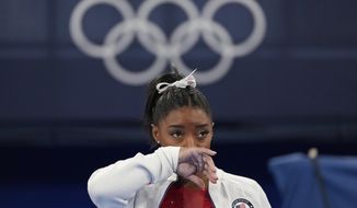 Simone Biles, of the United States, watches gymnasts perform after an apparent injury, at the 2020 Summer Olympics, Tuesday, July 27, 2021, in Tokyo. Biles withdrew from the team finals. (AP Photo/Ashley Landis)