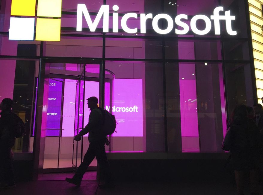 In this Nov. 10, 2016, photo, people walk past a Microsoft office in New York. Three tech companies that have amassed unparalleled influence while reshaping the way we live released their latest quarterly report cards in a flurry late Tuesday, July 27, 2021. Although Apple, Microsoft and Google owner Alphabet Inc. make their money in different ways, the results for the April-June period served as another reminder of the clout they wield and why government regulators are growing increasingly concerned about whether they have become too powerful. (AP Photo/Swayne B. Hall) **FILE**