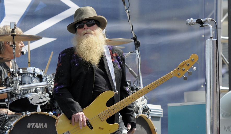 Dusty Hill, of ZZ Top, performs before the start of the NASCAR Sprint Cup series auto race in Concord, N.C., on May 24, 2015. ZZ Top has announced that Hill, one of the Texas blues trio's bearded figures and bassist, has died at his Houston home. He was 72. In a Facebook post, bandmates Billy Gibbons and Frank Beard revealed Wednesday, July 28, 2021, that Hill had died in his sleep. (AP Photo/Mike McCarn, File)