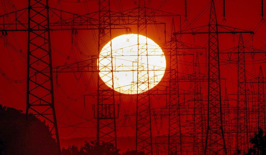 In this June 23, 2020, file photo, the sun rises behind power poles in Frankfurt, Germany. Electricity demand in the European Union has returned to pre-pandemic levels without a corresponding rise in power sector emissions, according to a report published Wednesday by the energy think tank Ember. (AP Photo/Michael Probst, File)
