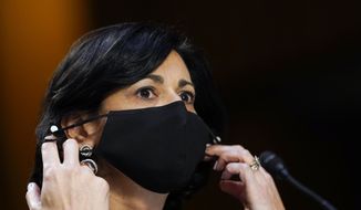 FILE - Dr. Rochelle Walensky, director of the Centers for Disease Control and Prevention, adjusts her face mask during a Senate Health, Education, Labor and Pensions Committee hearing on the federal coronavirus response on Capitol Hill in Washington, in this Thursday, March 18, 2021, file photo. Walensky says new mask-wearing guidance, coupled with higher rates of vaccination against COVID-19, could halt the current escalation of infections in “a couple of weeks.” The director of the Centers for Disease Control and Prevention told “CBS This Morning” she hopes more stringent mask-wearing guidelines and other measures won’t be necessary as the country heads into the fall.  (AP Photo/Susan Walsh, Pool, File)