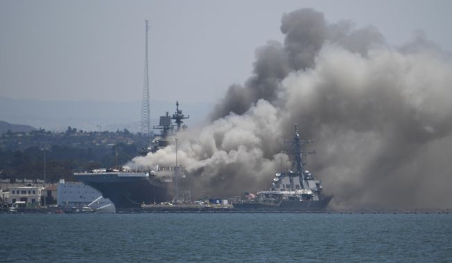 In this July 12, 2020, file photo, smoke rises from the USS Bonhomme Richard at Naval Base San Diego in San Diego after an explosion and fire. The U.S. Navy said Thursday, July 29, 2021, that charges have been filed against a sailor who is accused of starting a fire last year that destroyed a warship docked off San Diego. The amphibious assault ship called the USS Bonhomme Richard burned for more than four days and was the Navy&#x27;s worst U.S. warship fire outside of combat in recent memory. (AP Photo/Denis Poroy, File)  **FILE**